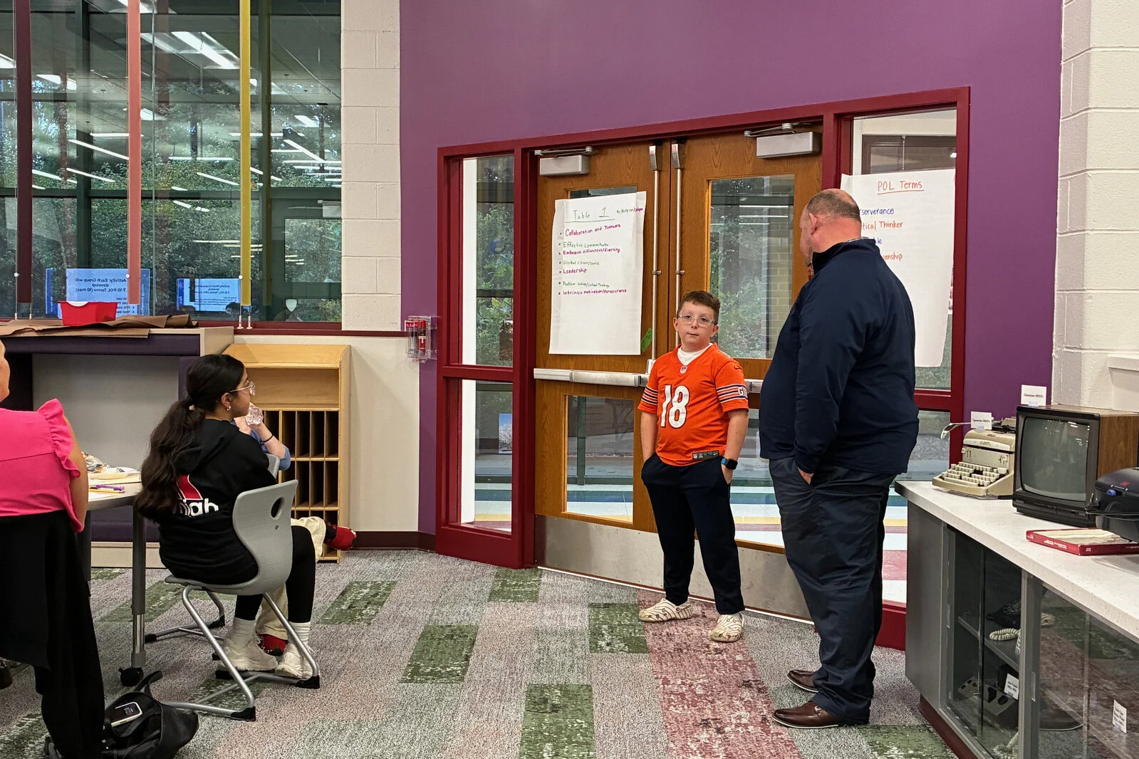Portrait or a Learner meeting 2 - a male student and school principal present to the committee at Meadowview School